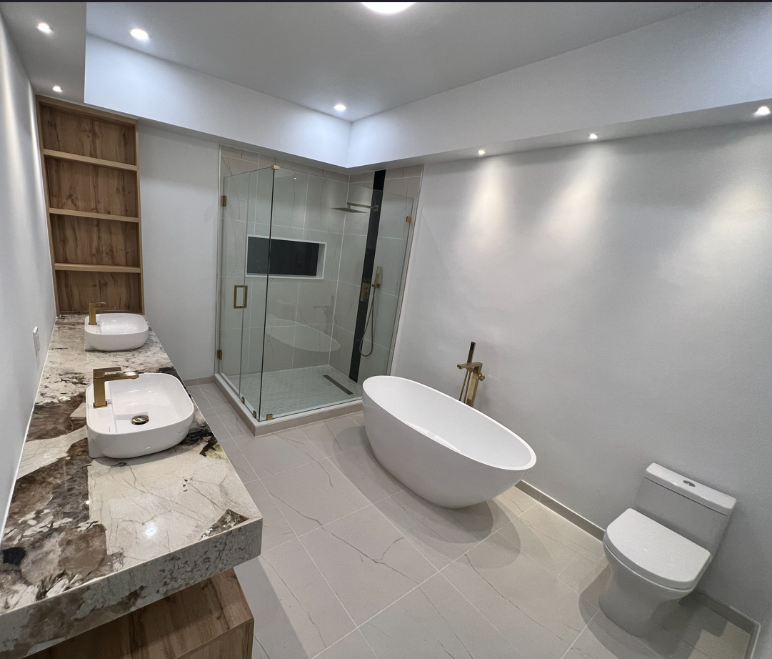 Remodeled bathroom with a freestanding tub, glass shower, and new fixture locations