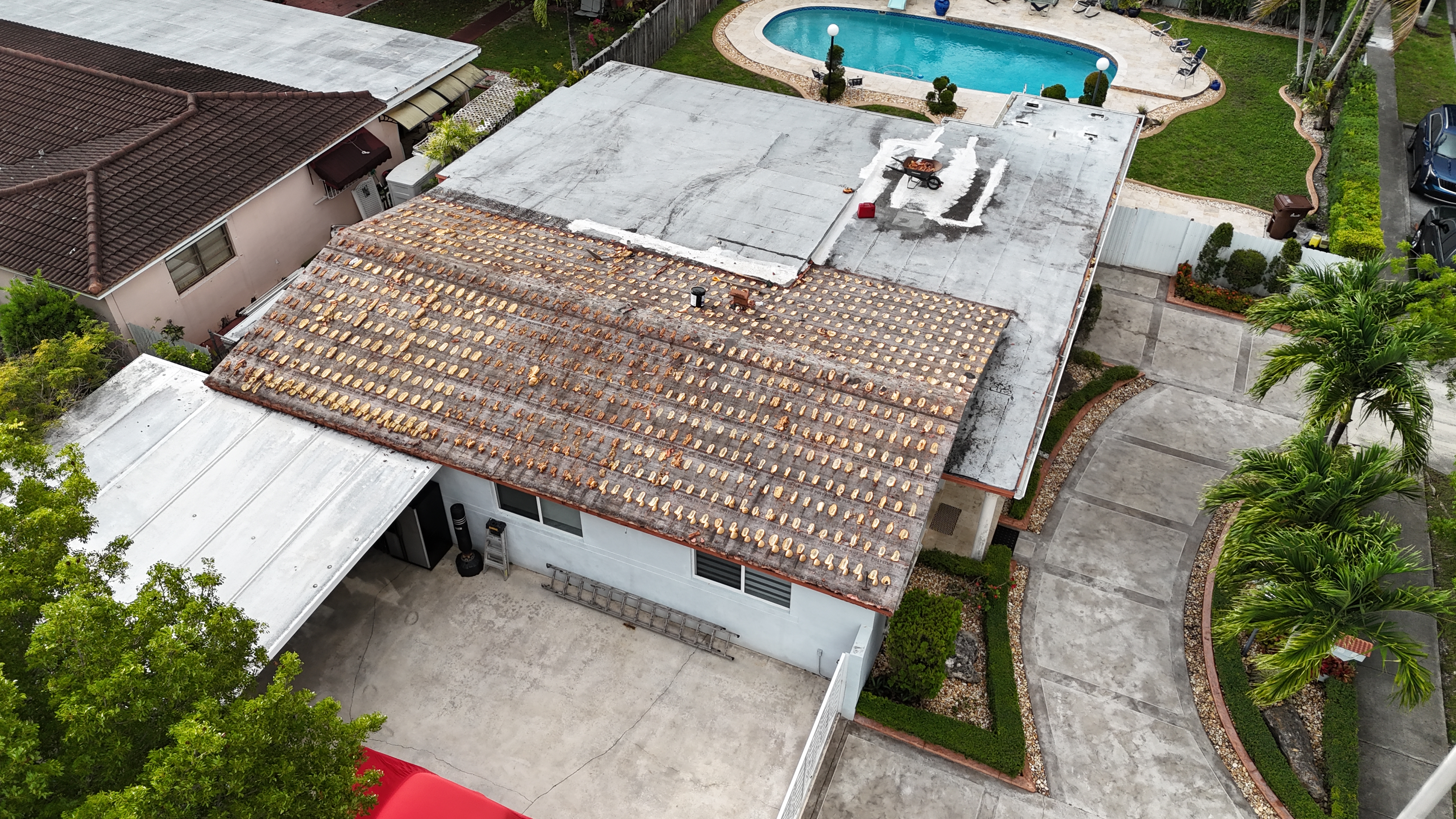 Aerial view of a failed tile roof stripped down to felt before replacement